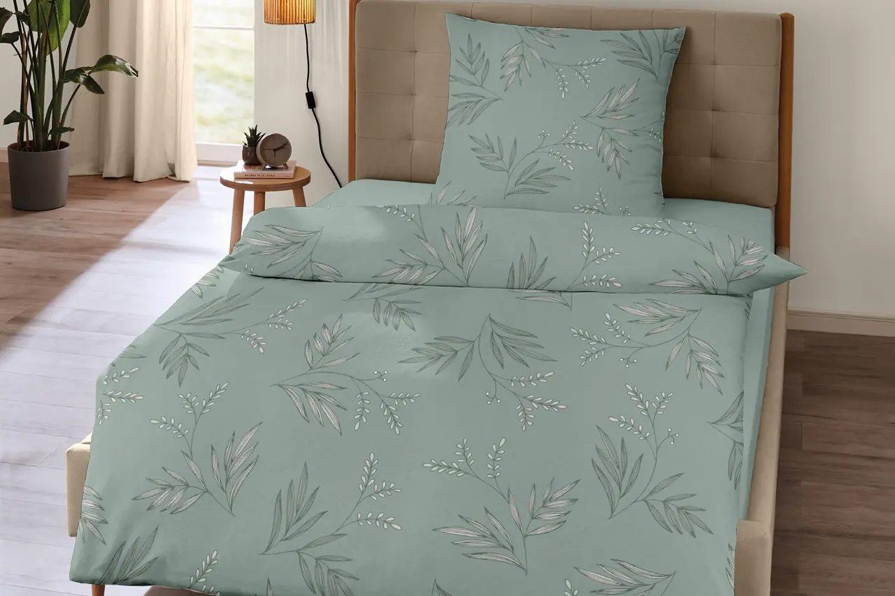 Moderne Bettwäsche in Grün mit dezentem Blattmuster auf gepolstertem Bett, hochwertige Schlafzimmer Textilien für erholsamen Schlaf und stilvolle Schlafzimmer Einrichtung